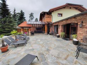 a patio with chairs and tables and a building at Wellness Penzion Na Kamyncu in Jablunkov