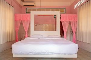 a pink bedroom with a white bed and pink curtains at Út Pink in Ấp Xuân Sơn