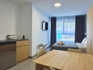 ein Hotelzimmer mit Bett, Tisch und Küche in der Unterkunft Sagra Hotel in Alicante