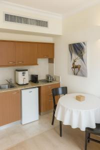 a kitchen with a white table and a white refrigerator at מגדל אלמוג חיפה - דירות "בלו ביץ'" על הים in Haifa