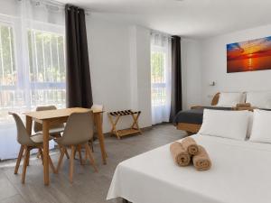 ein Schlafzimmer mit zwei Betten und einem Tisch sowie ein Esszimmer in der Unterkunft Sagra Hotel in Alicante