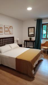 a bedroom with a large bed and a desk at Casa Ceferinos in Muxia