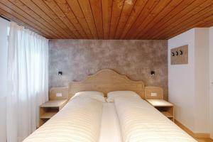 a bedroom with a bed with a wooden ceiling at Appartamento Sas Ciapel con biosaun in Arabba
