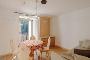 a living room with a table and a couch at Appartamento Aurone - con Biosauna in Arabba