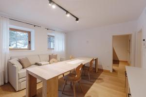 a living room with a table and a couch at Appartamento Borésc - area wellness in Arabba