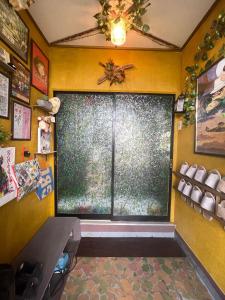 a room with a large window in a yellow wall at ゲストハウスこだまのおうち in Asahikawa +19 photos