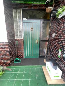 a front door of a brick house with a green door at ゲストハウスこだまのおうち in Asahikawa