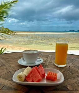 a plate of fruit and a cup of coffee and a glass of orange juice at Papillon Resort in Chaweng