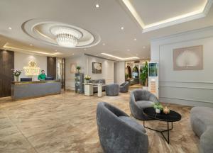 a lobby of a hotel with chairs and a counter at Minasi Grand Hotel in Hanoi