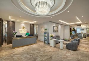 a lobby with a woman standing at the counter in a salon at Minasi Grand Hotel in Hanoi