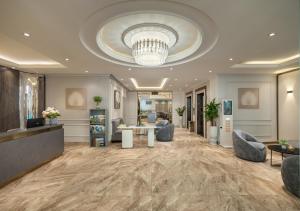 a lobby with a chandelier and a waiting room at Minasi Grand Hotel in Hanoi +93 photos