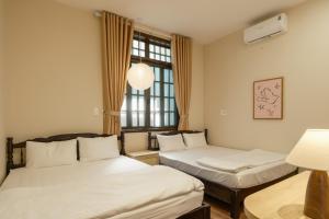 a room with two beds and a window at Tổ Homestay in Thôn Kim Long (1)