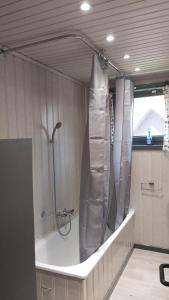 a bathroom with a shower with a shower curtain at Chalet Balthazar in Durbuy +36 photos