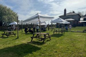 a group of picnic tables with umbrellas in a field at Pewsey Countryside Dome - Dog Friendly - Fire pit in Pewsey