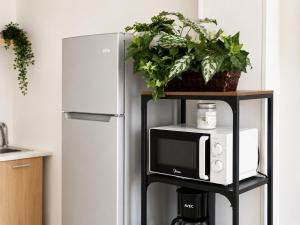 a microwave on a stand next to a refrigerator at Oasis - Cosy Studio in Larnaca in Larnaca