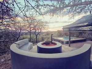a hot tub sitting on a deck next to a pool at ZuriCamp - Tent Madini in Tsumeb