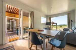 a living room with a wooden table and chairs at Macondo Agriliving Tiny Houses in Castiadas