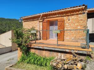 a house with a balcony on the side of it at Auberge du Bourguet in Brenon