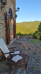a chair and a table on a stone patio at Torre della Soara - Medieval Tower in the Umbrian Countryside in Città di Castello