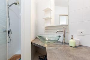 a bathroom with a glass bowl sink on a counter at Appartement Les Jardins in Saint-Vincent-de-Tyrosse +15 photos