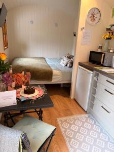 a small room with a bed and a table with a cake on it at Hut in the hall in Bedale +25 photos