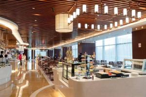 a restaurant with tables and chairs in a building at China National Convention Center Grand Hotel in Beijing