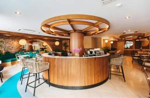 a restaurant with a bar with chairs around it at Rawai Sea Escape 1BR With Rooftop Pool in Rawai Beach