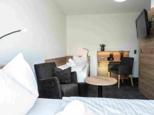 a room with a bed and a desk and a couch at Hotel Zum Steinhof in Bad Blankenburg