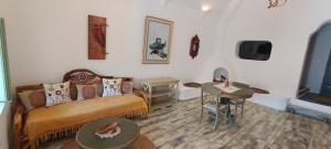 a living room with a couch and a table at Aliori art caves in Aegiali