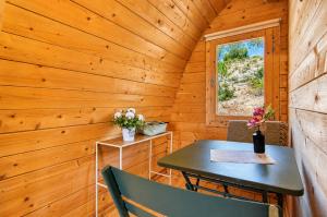 a table and chair in a wooden room with a window at Cabaña Massdepiedra in Sax +16 photos