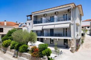 ein Mehrfamilienhaus mit Balkonen und Büschen in der Unterkunft Mageiras Boutique Hotel in Afytos