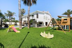 a yard with playground equipment in front of a house at Villa Dalia con piscina in Partinico