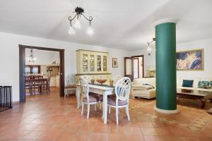 a dining room and living room with a green column at Villa Dalia con piscina in Partinico