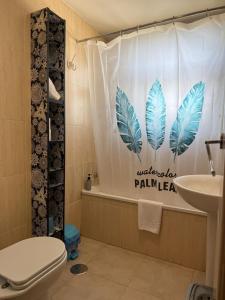 a bathroom with a shower curtain with a toilet and a sink at APARTAMENTOS INFINITY in Sierra Nevada +21 photos