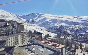 an aerial view of a city with snow covered mountains at APARTAMENTOS INFINITY in Sierra Nevada