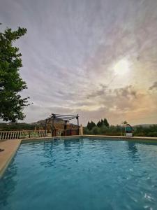 a large swimming pool with a playground in the background at Casa Rural El Cuco in Luque