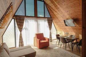 a living room with a couch and a table with chairs at Tengri Village Karakol in Karakol