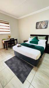 a bedroom with a large bed and a desk at Hendrinas Guesthouse in Hendrina