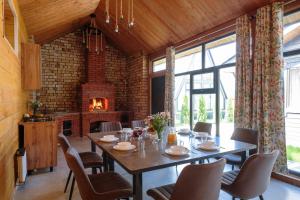 a dining room with a table and a fireplace at Tengri Village Karakol in Karakol