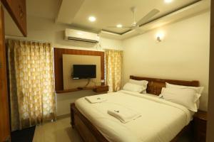 a bedroom with a large bed with a tv on the wall at SR Castle Gopalapuram in Chennai