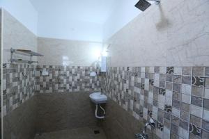 a tiled bathroom with a sink and a shower at SR Castle Gopalapuram in Chennai