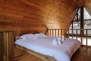 a bedroom with a bed with three pillows on it at Tengri Village Karakol in Karakol