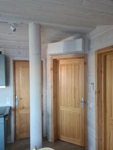 two wooden doors in a room with a column at Finn Lodge in Saint-Denis-dʼOléron