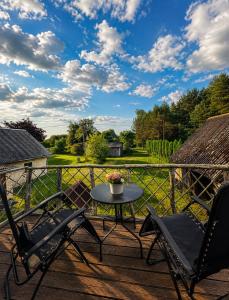 a patio with two chairs and a table on a deck at Cenkones Bungalow in Cenkoņi