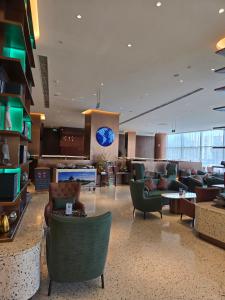 a lobby with couches and chairs in a hotel at China National Convention Center Grand Hotel in Beijing +32 photos