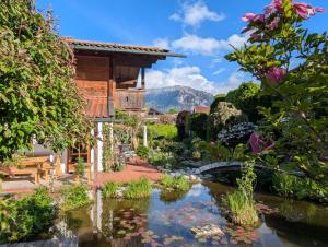 a garden with a pond in front of a house at Ferienwohnung Rösslstube in Ruhpolding