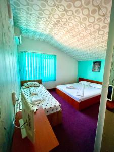 two twin beds in a room with a ceiling at Casa LariCris in Corbu +15 photos
