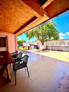 a patio with chairs and a table and a tree at Casa LariCris in Corbu