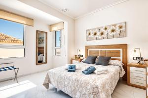 a bedroom with a bed with two blue pillows on it at The Triplets in Agres