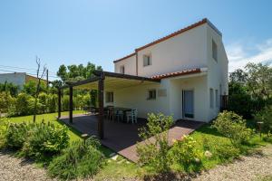 a backyard with a deck and a house at Macondo Agriliving Apartments in Castiadas